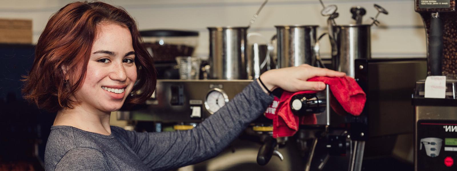 Woman making espresso at cafe